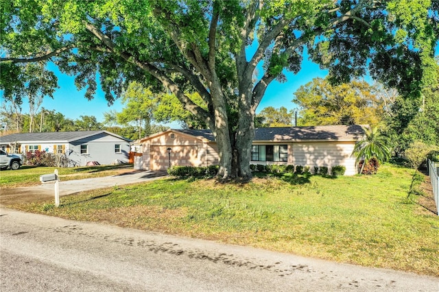 ranch-style house featuring a front lawn and a detached garage