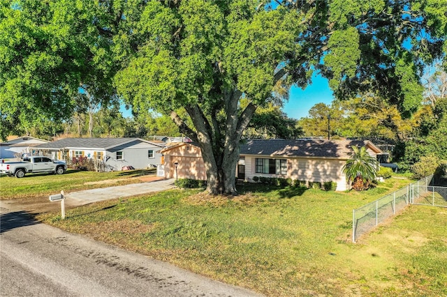 ranch-style house with a front lawn, fence, and driveway