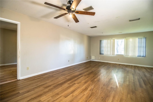 empty room with visible vents, baseboards, and wood finished floors