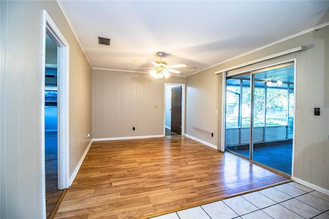 unfurnished room with ceiling fan, baseboards, light wood-type flooring, and ornamental molding