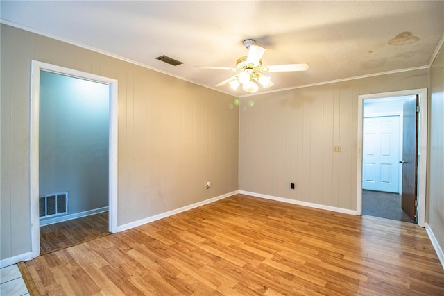 unfurnished room with visible vents, light wood-style flooring, and ornamental molding