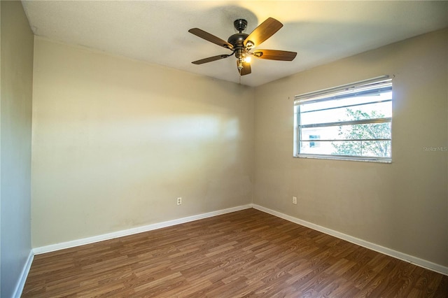 spare room featuring ceiling fan, baseboards, and dark wood-style floors