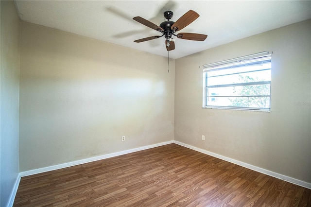 unfurnished room featuring a ceiling fan, baseboards, and wood finished floors