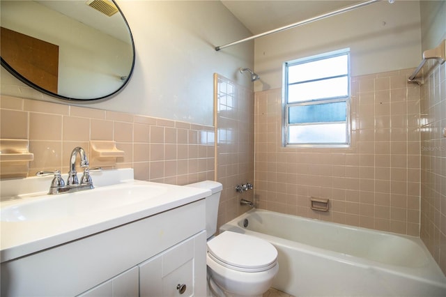 full bath with vanity, visible vents, tile walls, toilet, and shower / bathtub combination