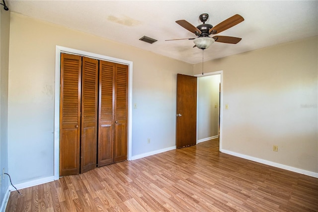 unfurnished bedroom with baseboards, visible vents, ceiling fan, a closet, and light wood-type flooring