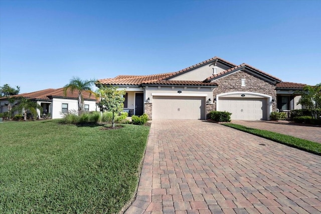 mediterranean / spanish house featuring decorative driveway, stone siding, a garage, and a tile roof