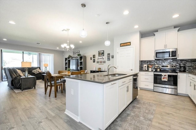 kitchen featuring a sink, dark countertops, open floor plan, and stainless steel appliances