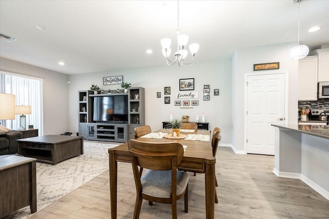 dining room featuring visible vents, baseboards, recessed lighting, light wood-style floors, and a notable chandelier