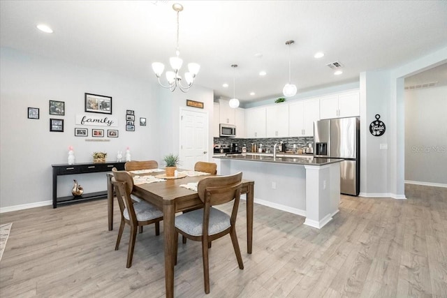 dining room with recessed lighting, visible vents, an inviting chandelier, and light wood-style floors