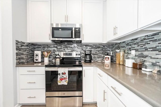 kitchen with stainless steel appliances, tasteful backsplash, and white cabinetry