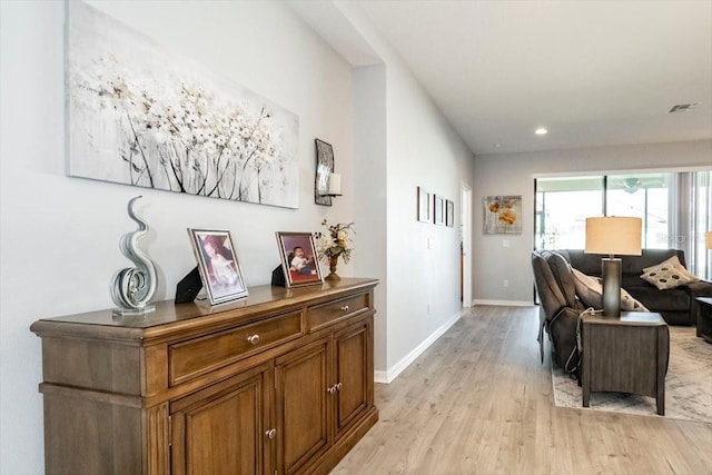 hallway featuring light wood-style flooring, recessed lighting, baseboards, and visible vents