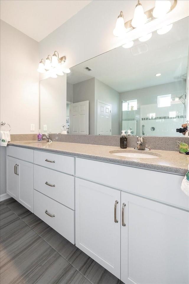 full bath featuring a sink, visible vents, and double vanity