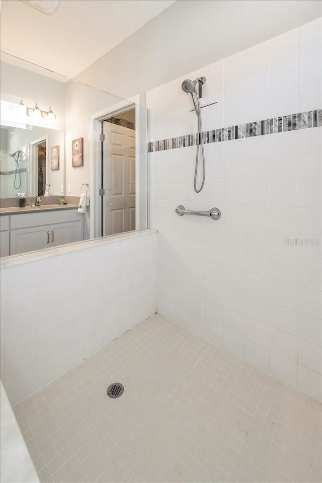 bathroom with a sink and tiled shower