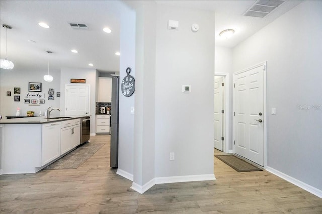 kitchen with light wood-style floors, visible vents, and dark countertops