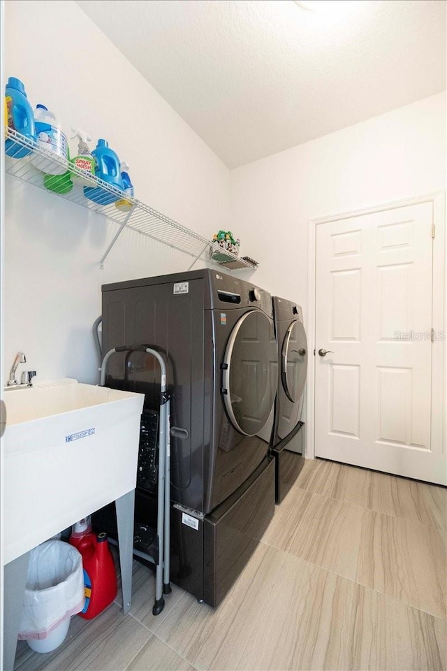 laundry room featuring laundry area, independent washer and dryer, and a sink