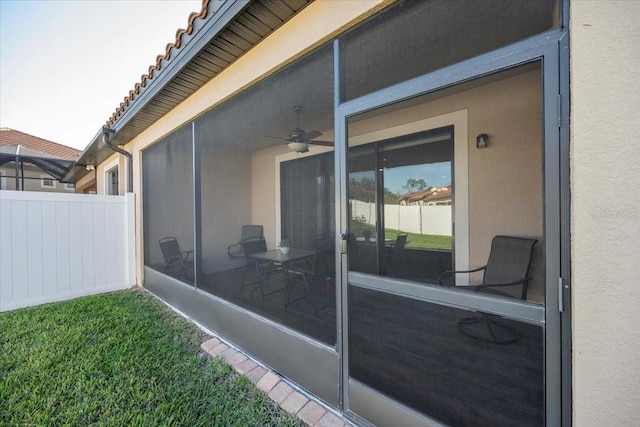 view of patio featuring fence and a sunroom