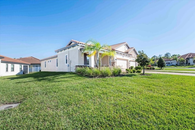 view of front of property with a tiled roof, a garage, a front lawn, and stucco siding