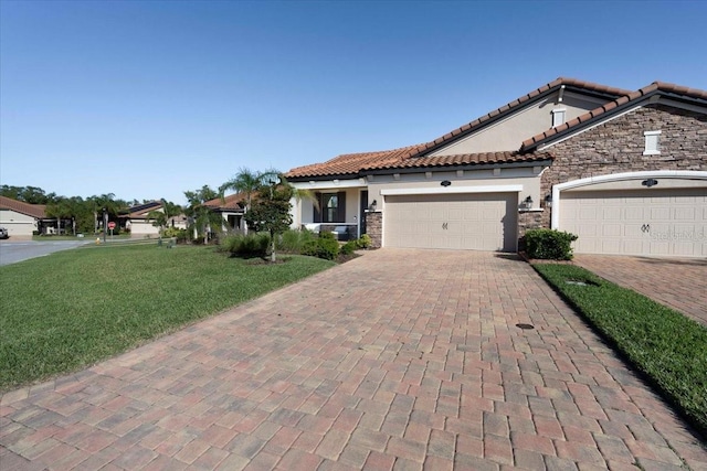 mediterranean / spanish-style home with stucco siding, a front lawn, decorative driveway, stone siding, and an attached garage