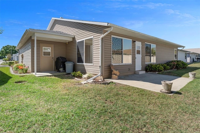 exterior space featuring a front lawn and a patio