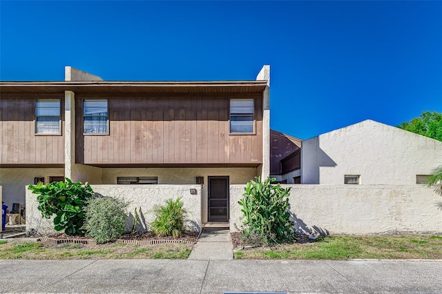 townhome / multi-family property featuring stucco siding and fence