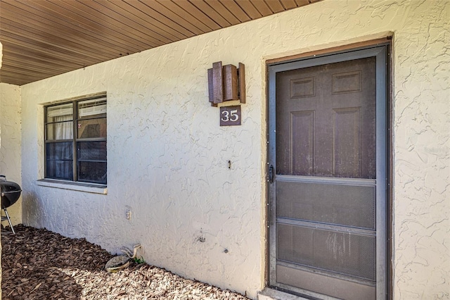 view of exterior entry with stucco siding