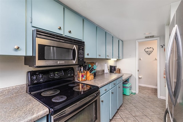 kitchen with baseboards, visible vents, blue cabinetry, light tile patterned flooring, and appliances with stainless steel finishes