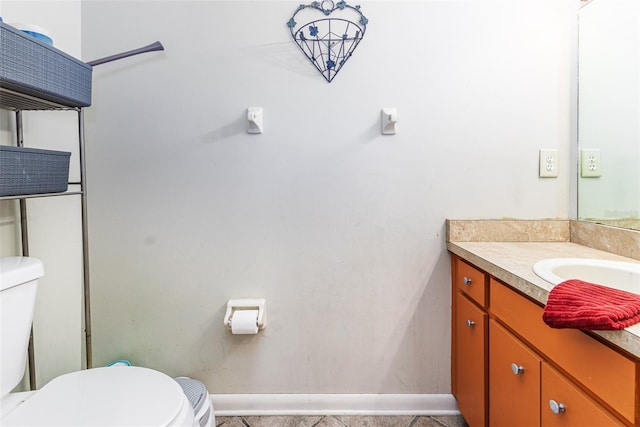 bathroom featuring vanity, toilet, and baseboards