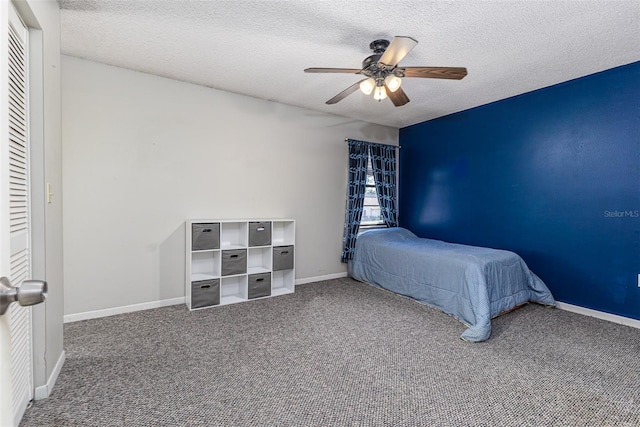 bedroom featuring a ceiling fan, baseboards, carpet floors, and a textured ceiling