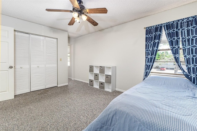 bedroom featuring ceiling fan, carpet, a closet, and a textured ceiling