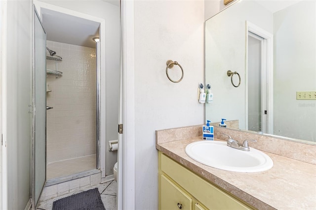 full bath featuring toilet, a stall shower, vanity, and tile patterned flooring