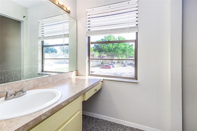 bathroom featuring a wealth of natural light, baseboards, and vanity