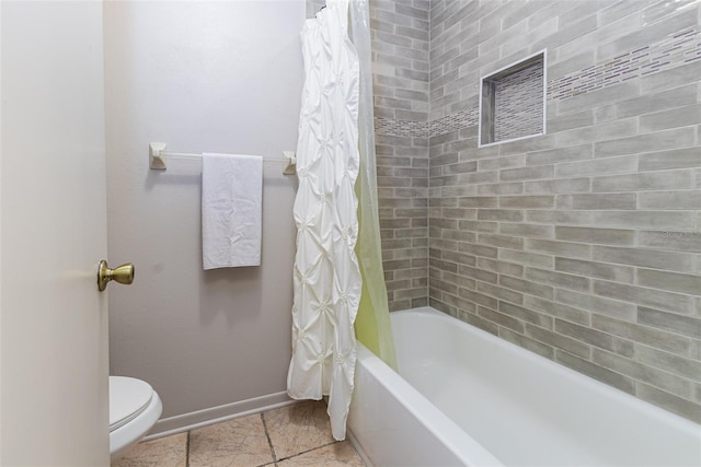 full bathroom with shower / bath combo with shower curtain, toilet, and baseboards