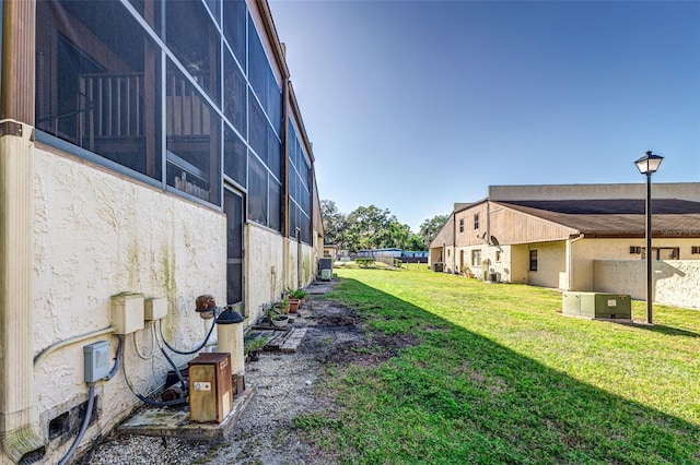 view of yard featuring central AC and a lanai