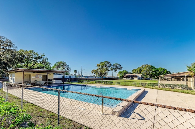 pool with a patio and fence