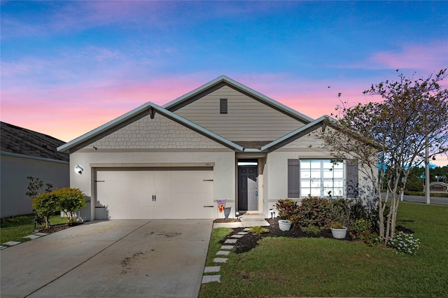 view of front of property featuring a yard, an attached garage, and driveway