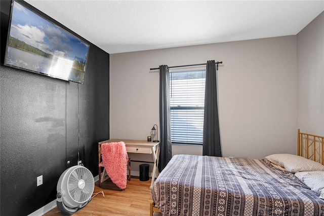 bedroom featuring baseboards and light wood-type flooring