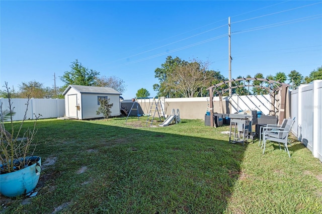 view of yard featuring an outdoor structure, a playground, a fenced backyard, and a shed