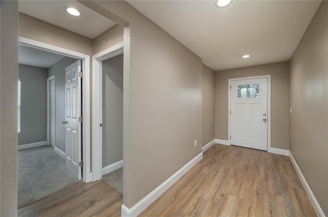 foyer with recessed lighting, light wood-type flooring, and baseboards