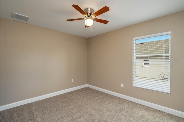 carpeted empty room with baseboards, visible vents, and ceiling fan