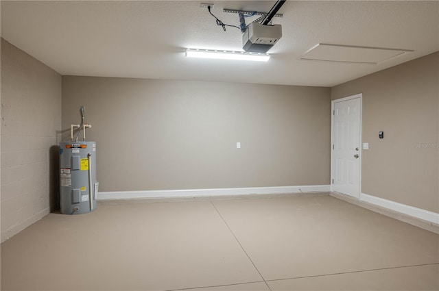 garage featuring water heater, concrete block wall, a garage door opener, and baseboards