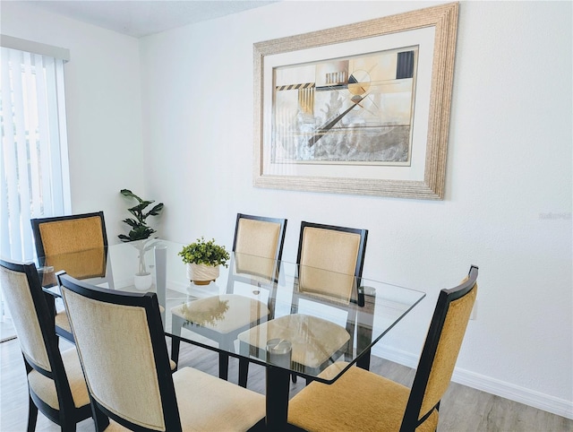 dining space featuring baseboards and wood finished floors