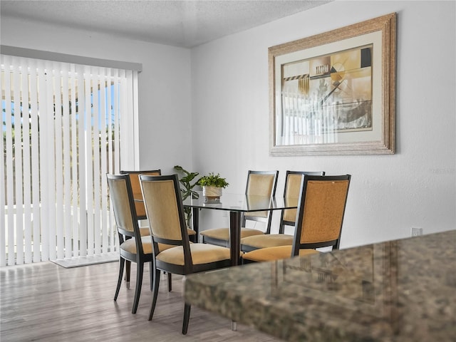 dining area featuring a textured ceiling and wood finished floors