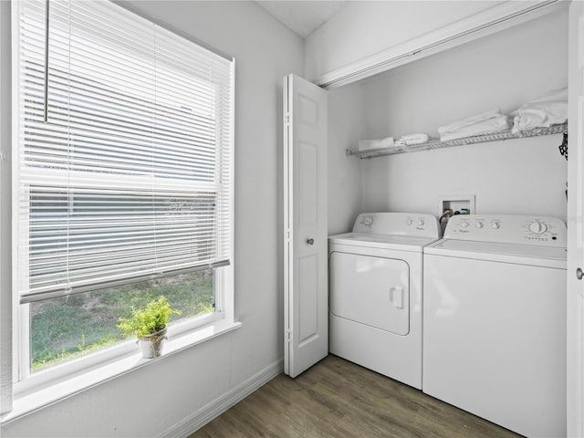 clothes washing area with laundry area, washing machine and dryer, baseboards, and wood finished floors