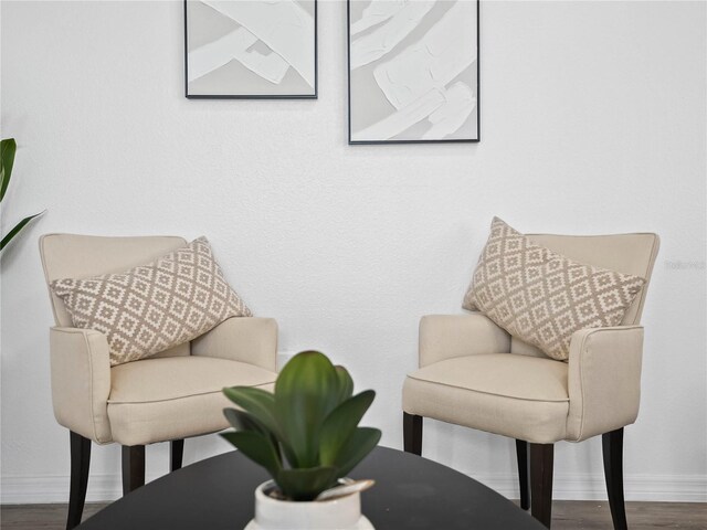 living area with baseboards and wood finished floors