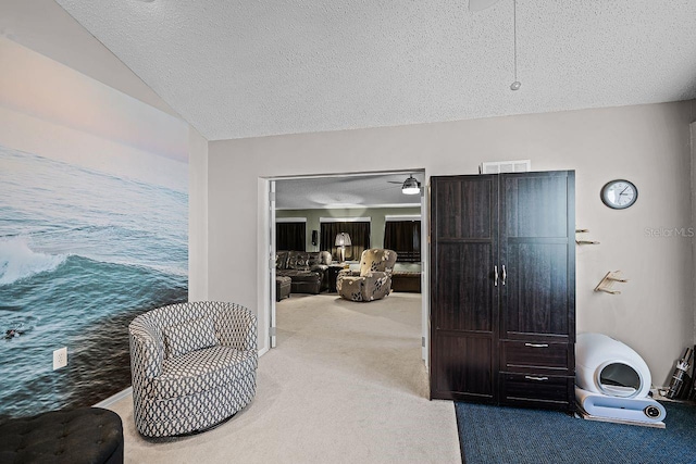 living area featuring visible vents, a textured ceiling, and carpet