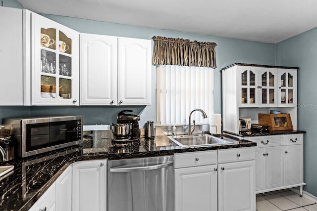 kitchen featuring a sink, stainless steel appliances, glass insert cabinets, and white cabinets