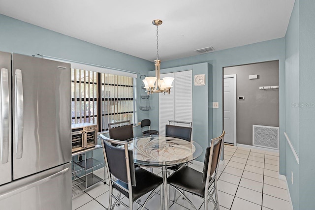 dining space featuring a notable chandelier, visible vents, baseboards, and light tile patterned flooring