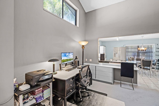 office featuring an inviting chandelier, a high ceiling, light tile patterned floors, and light carpet