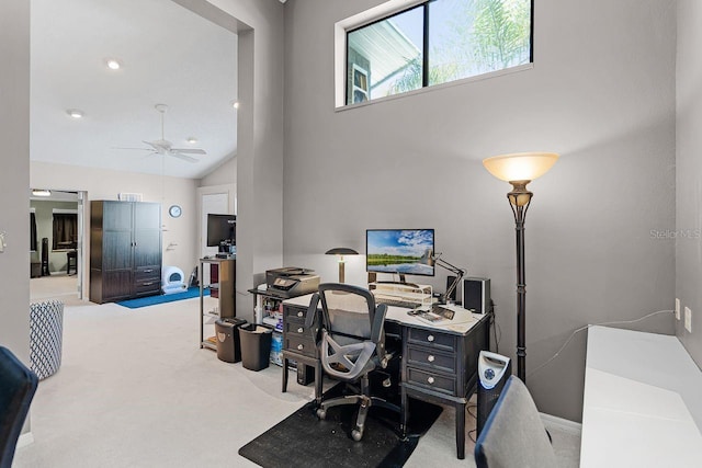 home office with high vaulted ceiling, ceiling fan, and carpet flooring