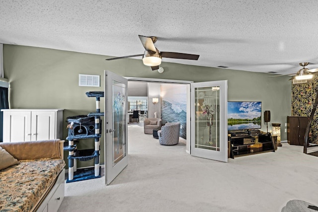 living room with visible vents, ceiling fan, carpet floors, french doors, and a textured ceiling